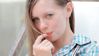 An innocent cutie with blue eyes stimulates her little hole